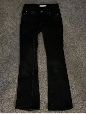 Svarta bootcut jeans från Junkyard XS - Säljer ett par svarta bootcut jeans från Junkyard i storlek XS. Jeansen har klassisk femficksdesign, låg midja!! och utsvängda ben. Tillverkade i ett mjukt och stretchigt denimtyg som sitter snyggt och bekvämt. Använd max 2 gånger typ säljer pga att de inte passar mig
