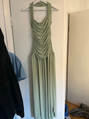ASOS - Sagegrön maxiklänning med halterneck - ALDRIG ANVÄND🤍 Köpte för att ha till bröllop men valde en annan och returtiden gick ut. SUPERsnygg ljusgrön maxiklänning från ASOS. Klänningen har ett långt, flödande fall och är tillverkad i ett tunt, mjukt tyg som ger en elegant look. 