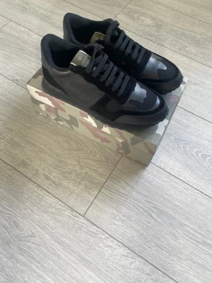 Valentino Rockrunner - Säljer ett par stilrena Valentino Rockrunner i svart, storlek 42. En klassisk och exklusiv sneaker som passar både till vardags och till lite mer uppklädda outfits. Säljes då de inte kommer till användning, använt 3-4 gånger. Hör gärna av dig vid intresse eller om du vill ha fler bilder.