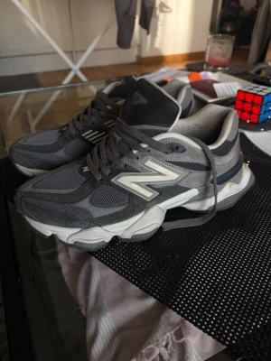 Grå New Balance sneakers - Säljer ett par gråa New Balance sneakers med chunky sula och klassisk N-logga på sidan. Skorna har en mix av mesh och mocka för en sportig och trendig look. Perfekta för dig som gillar streetwear och vill ha något bekvämt till vardags.
