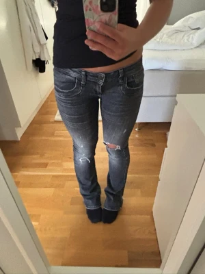 Grå slitna jeans från LTB - Säljer ett par gråa jeans från LTB, modell Valerie. Jeansen har slitningar och hål på ena knät för en trendig look. De har klassisk femficksdesign, låg midja och raka ben. Perfekta för dig som gillar en avslappnad och cool stil.