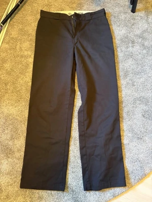 Svarta 874 från Dickies - Säljer ett par klassiska svarta chinos från Dickies. Byxorna har rak passform, diskret logga ovanför bakfickan och är tillverkade i ett slitstarkt bomullsmaterial. Perfekta för en clean och stilren look.
