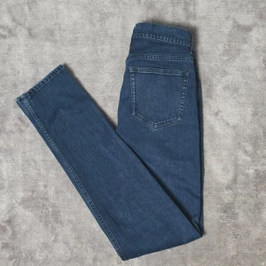 Acne Studios Ace Abyss jeans mörkblå 28/32 - Mörkblå jeans från Acne Studios i modellen Ace Abyss. Klassisk smal passform med lätt stretch och en tidlös mörkblå tvätt som passar både till vardag och mer uppklädda outfits.  Storlek 28/32  Fint skick. Litet märke höger smalben, knappt märkbart, se bild.  Mått  • Midja: ca 37 cm (mätt plant)  • Grenhöjd: ca 23 cm  • Ytterbenslängd: ca 106 cm  • Innerbenslängd: ca 80 cm  • Fotvidd: ca 15 cm  Material 98% bomull 2% elastan