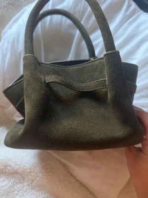 Olivgrön mocka handväska - Säljer en olivgrön handväska från shein. Har en liten ficka där inne 🥰