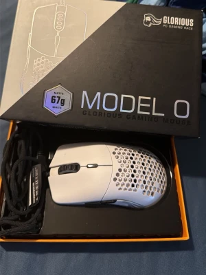 Glorious Model O gamingmus vit - Säljer en Glorious Model O gamingmus i matt vit färg. Musen har en lätt design med hål för bättre ventilation och väger endast 67 gram. Perfekt för gaming och har en flexibel svart kabel. Levereras i originalförpackning.