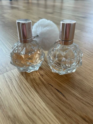 Parfymflaskor med diamantmönster - Två parfymflaskor i transparent glas med ett coolt diamantmönster och silvriga lock. Ena flaskan har en fluffig vit boll som dekoration. Flaskorna har en modern och lyxig känsla, perfekta att ha framme på sminkbordet. (Tillsammans blir det en hel) en är 30ml