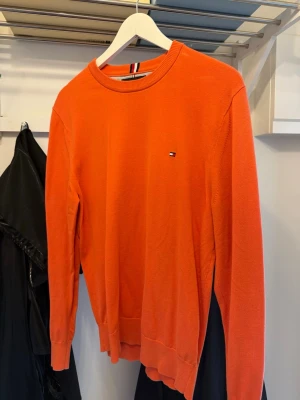 Orange stickad tröja Tommy Hilfiger - Skit fräsch tröja från Tommy hilfiger, använd den några gånger men är nästan som ny! Storlek M och den sitter riktigt bra på kroppen! 