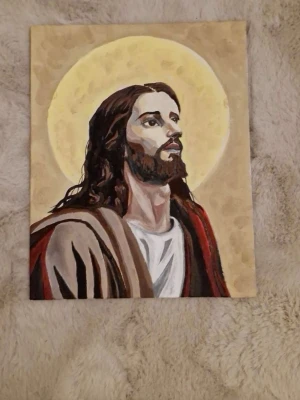 Målad tavla med religiöst motiv - Unik handmålad tavla som föreställer jesus med långt brunt hår och skägg, klädd i bruna och röda toner. Bakgrunden är beige med en stor gul sol bakom huvudet. Perfekt som dekoration för dig som gillar konst med religiösa inslag. Målat själv, 24x30cm
