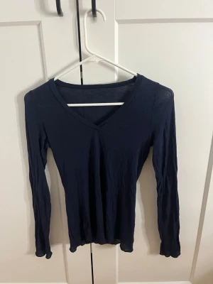 Mörkblå långärmad v-ringad tröja från intimissimi  - Säljer en mörkblå långärmad topp med v-ringning i storlek s från intimissimi 