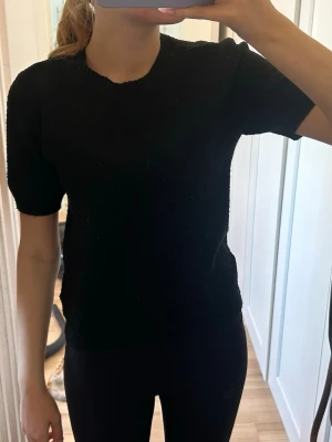 Svart stickad t-shirt - En enkel svart stickad t-shirt med korta ärmar och rund hals. 