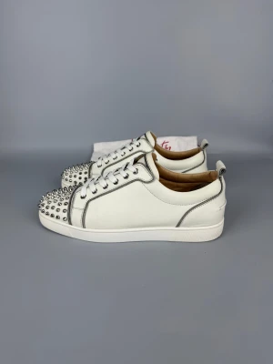 Christian Louboutin Louis Junior Spikes Sneaker | 45 - Vita sneakers från Christian Louboutin i mycket gott skick. Dustbag ingår.