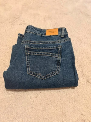 Mörkblå low waist straight jeans från Gina tricot - Säljer ett par snygga mörkblå jeans från Gina tricot. De är low waist, straight och i storlek 36. Endast använda en gång och nytt skick utan prislapp. De har snygga kontrastsömmar och en annorlunda bakfickedesign. Perfekta för en stilren look.                                                               Kontakta för fler bilder/frågor💕