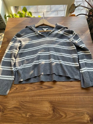 Grå stickad tröja med vita ränder - Mysig grå stickad tröja med vita horisontella ränder och en avslappnad krage. Tröjan har lång ärm och en något lös passform. Perfekt för dig som gillar en enkel men stilren look. Tveka inte på att skriva en fråga eller be om fler bilder🌸🌸