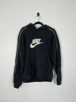 Nike Hoodie Svart Vintage Y2K Broderad Logo Herr Unisex Strl S - • Storlek: S • Färg: Svart • Passform: Regular Fit • Krage: Huva • Material: 80% bomull & 20% polyester  Skick: Plagget är i ett fint skick. Eventuella anmärkningar anges alltid tydligt i beskrivningen och visas på bilderna.  Nypris: Cirka 500 kr.  📦 Skickas snabbt och packas omsorgsfullt. 💬 Hör gärna av dig om du har frågor eller vill se fler bilder. 🤝 Samfrakt erbjuds vid köp av flera plagg – kika gärna in mina andra annonser!