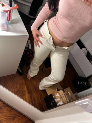 Vita raka jeans med hög midja - Säljer ett par vita jeans med rak passform och hög midja. Jeansen har klassisk femficksdesign och stängs med dragkedja och knapp. Perfekta för en clean och fräsch look till vardags. Materialet är denim med lite stretch för extra komfort. Defekt: smuts längst  ner 