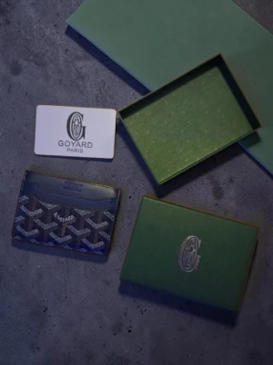 Go4ard korthållare i blått mönster Royal blue - Snygg korthållare från Go4ard i blått med deras ikoniska mönster i vitt och grått. Tillverkad i läder och canvas, perfekt för kort och ID. Kommer med originalask och certifikat. En stilren accessoar för dig som gillar exklusiva detaljer. Nytt skick med öppet paket