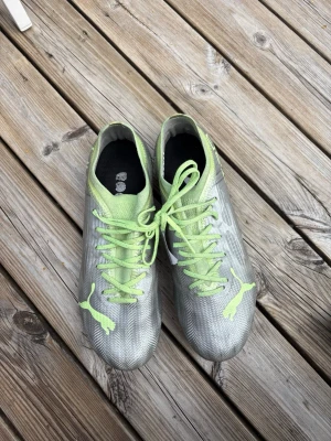 Puma fotbollsskor  - Ett par silvriga Puma Ultra fotbollsskor med gröna detaljer i storlek 39! Nästan helt oanvända