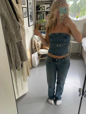 Jeanstopp - Säljer en snygg jeans topp med snygga detaljer. Har en viss färgning vid bysten se bild tre, men inget man tänker på vid användning. 