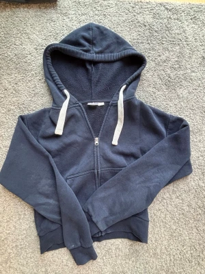 Mörkblå ziphoodie från Gina Tricot - Mörkblå ziphoodie från Gina Tricot i storlek XS. Säljer pågrund av att den är för liten tyvärr. 