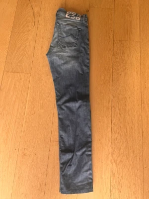 Jacob Cohen jeans w26 - Säljer dessa sjukt snygga Jacob Cohen jeans i w26. De är i bra skick förutom ett litet hål vid skrevet och några lösa sömmar längst ner men båda grejerna är inget som tydligt märks. De sitter slim, hör av er vid funderingar!