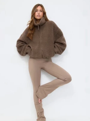 Brun teddyjacka med hög krage - Mysig brun teddyjacka med hög krage och dragkedja framtill. Jackan har en oversized passform och är gjord i fluffigt teddy-material som ger en trendig look. Perfekt för kyliga dagar och enkel att styla till olika outfits. ”Den är köpt begagnat. Dock skulle jag säga att det är en annan färg än vad den lånade bilden säger. Men det är snygg ändå.