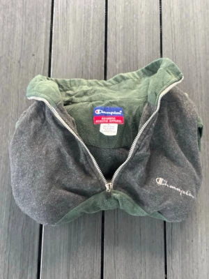 Grågrön fleecehoodie från Champion - • Size XL • Champion brand • Color block green and grey • 100% polyester fleece material • Half-zip closure • Embroidered Champion logo • Good used condition • Smoke & pet free home