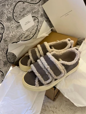 Inuikii sneakers  - INUIKII Sneakers Shearling Low Velcro. Älskar dessa men har inte kommit till användning. Använda max 2/3 gånger så dom är helt som nya! Inga skavanker över huvud taget och lika fräscha som nya. Supermysiga till hösten!! Köptes för 2600 förra säsongen då de var slutsålda nästan hela tiden! Färgen heter grey men skulle säga att dom är kallt beigea i färgen. 