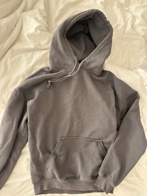 Grå hoodie från BikBok - Mysig grå hoodie från BikBok med huva och dragsko. Klassisk känguruficka framtill och ribbade muddar vid ärmslut och nederkant. Perfekt nu till hösten. 
