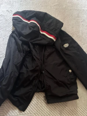 Moncler windbreaker  - Svart Windbreaker från moncler, i gott skick. Dragkedjan kan vara lite trög men inget är trasigt på den. Storlek M och säljer då den ej kommer t användning. Kom gärna med egna bud. 