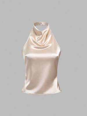Champagnefärgad/rosa halterneck linnetopp - Snygg champagnefärgad/rosa halterneck topp i satin med draperad front och smala band som knyts i ryggen. Toppen har en elegant glansig finish och öppen rygg, perfekt för en trendig look.