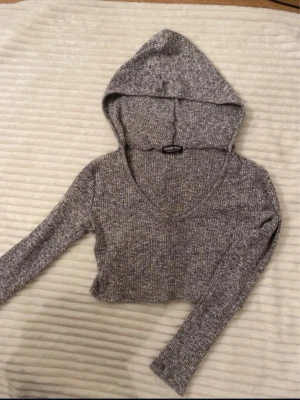Gråmelerad cropped hoodie - Super fin cropped hoodie från Fashionnova, har tyvärr inte kvar storlekslappen då den kliade😞 men är helt säker på att den är i storlek S!