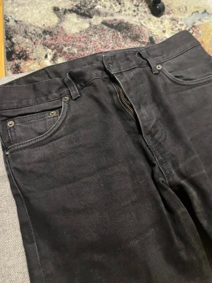 Svarta raka jeans med dragkedja - Säljer ett par svarta jeans med klassisk femficksmodell och dragkedjegylf. Jeansen har raka ben och är tillverkade i ett slitstarkt denimtyg. Passar perfekt till en avslappnad och stilren look. Storlek 30/34