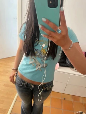 Blå Ed Hardy t-shirt med tryck - Skiiiitsnygg ed Hardy tshirt som är perfekt nu på sommaren när man fått lite färg 😍har litet hål i armhålan (sista bilden) men inget som syns när man har på sig den! Skulle säga storlek 36