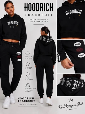 Svart cropped hoodie från Hoodrich - Snygg svart cropped hoodie från Hoodrich med stor vit logga på bröstet och tryck på huvan. Hoodien har dragsko i huvan och ribbade muddar vid ärmsluten. Perfekt för dig som gillar streetwear och vill ha en trendig look.