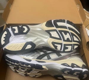 Asics Gel Keyano  - Snygga sneakers i silver och vitt med svarta och beige detaljer. 