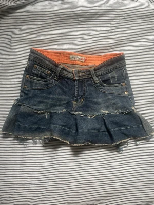 jeanskjol med volang w24 - Säljer en mörkblå jeanskjol med volangkant och slitna detaljer. Pris kan diskuteras.💕