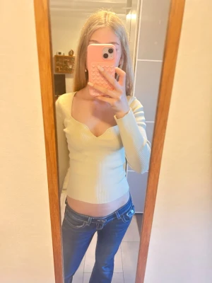 Ljusgul ribbad topp med v-ringning - Trendig ljusgul ribbad topp med lång ärm och snygg v-ringad hals. Figurnära passform som passar perfekt till jeans eller kjol. Tillverkad i mjukt material som känns skönt mot huden. Enkel men stilren design som är lätt att matcha.