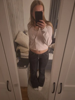 Svarta bootcut jeans - Säljer ett par svarta bootcut jeans med låg midja. Jeansen har klassisk femficksdesign och är tillverkade i ett robust denimtyg. Perfekta för dig som gillar en retro och avslappnad stil.