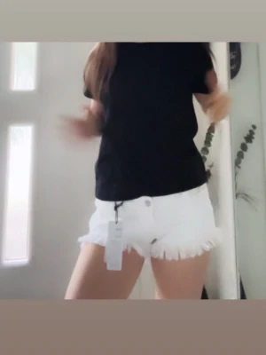 Vita fransiga shorts med hög midja - Säljer ett par vita shorts med låg midja och fransiga benslut. Shortsen har klassisk femficksdesign och stängs med knapp och dragkedja. Perfekta för sommaren och ger en avslappnad men trendig look. Dom är helt nya och aldrig använt dom! 