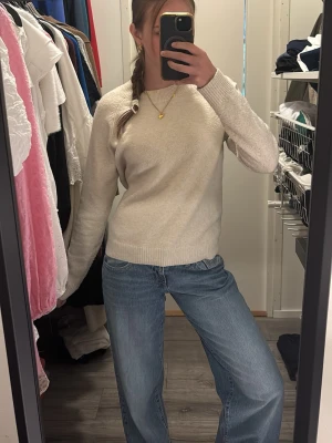 Beige stickad tröja  - Mysig beige stickad tröja med rund hals och långa ärmar. Tröjan har ribbade muddar vid ärmslut och nederkant, vilket ger en klassisk och enkel look. Går att matcha med typ vad som helst.