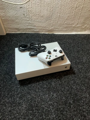 Xbox One S vit spelkonsol med handkontroll - Säljer en Xbox One S i snygg vit design med tillhörande vit trådlös handkontroll och strömkabel. Säljer då de ej kommer till användning, se på bild två den knappen som är inringad är glapp men annars funkar allt som de ska. Svarar på frågor, och priset är inte satt i sten men helst inte under 950 (då jag köpte de för 3500, när de nyss hade kommit ut)🌷😊                   tack på förhand 