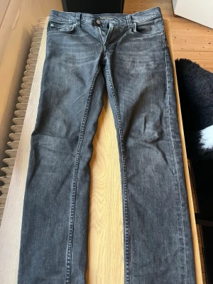 Svarta slim fit jeans - Säljer ett nudie jeans i modellen lean Dean. Jeansen har en lätt tvättad look och raka ben. Perfekta till en avslappnad stil och passar till det mesta i garderoben.