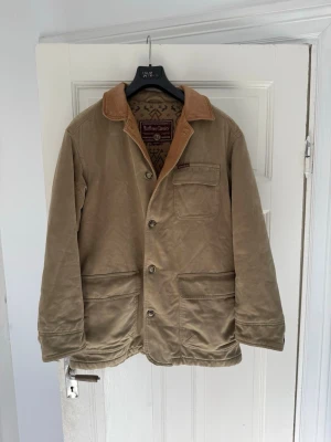 Marlboro Classics Vintage Jacket 90s - Säljer nu denna ovanliga och äkta vintage Marlboro Classics-jacka i mycket fint skick från 90s. Beige/khaki canvas med brun kontrastkrage och det klassiska mönstrade Marlboro Classics-fodret. Storlek M men är åt det större hållet så skulle säga att den passar L också. Inga hål, skador eller liknande. Väldigt fint vintage skick helt enkelt. Tar emot Rimliga bud. Mvh 