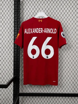 Liverpool matchtröja Alexander-Arnold - Röd Liverpool FC matchtröja från New Balance med vita detaljer och tunna vertikala ränder. Nummer 66 och Alexander-Arnold på ryggen. Klubbmärke och sponsortryck på bröstet, samt gula detaljer på ärmarna. Tillverkad i lätt och ventilerande material.
