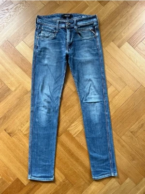 Replay jeans - Snygga blå slim fit jeans med lätt slitna detaljer och klassisk femficksdesign. Jeansen har normal midja, smala ben och kontrastsömmar. Tillverkade i denim med stretch för extra komfort. Perfekta för en avslappnad och trendig look.