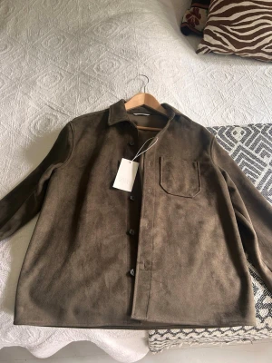 Brun overshirt från Zara - Brun mocka overshirt från Zara. Köpt för 799kr. Aldrig använd då den ej passar mig.