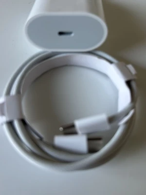 Vit USB-C laddare och kabel - Säljer en vit USB-C laddare tillsammans med en matchande USB-C till USB-C kabel. Perfekt för att ladda mobiltelefoner och andra enheter. Sladden är flätad för extra hållbarhet och båda delarna har en stilren och enkel design i plast.