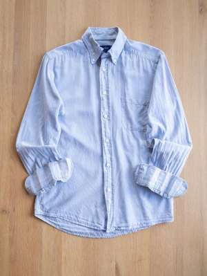 Ljusblå skjorta från Eton - Säljer en stilren ljusblå skjorta från Eton. Skjortan har button down-krage, bröstficka och vita knappar. Perfekt för dig som gillar en avslappnad men ändå snygg look. Ärmarna är långa och kan enkelt vikas upp.