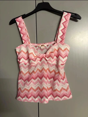 Linne Gina Tricot  - Tight linne med zick-zackmönster. Linnet är rosa och har knytdetalj vid bysten. Det har breda axelband, fodrade kupor och stretchigt material Storlek S 14 +