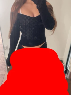 Svart offshoulder topp med mönster - Trendig svart offshoulder topp med långa ärmar och diskret cirkelmönster. Toppen har en tight passform och är perfekt för dig som vill ha en stilren men ändå unik look. Tillverkad i mjukt material som sitter skönt mot kroppen.